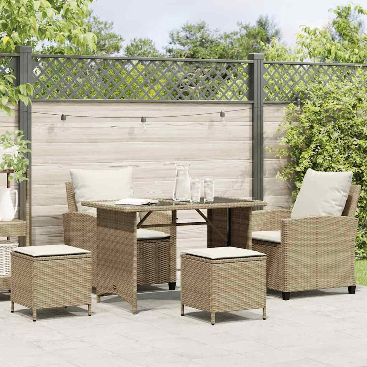 Set di mobili da esterno in vimini beige: tavolo, due sedie e due pouf con cuscini.