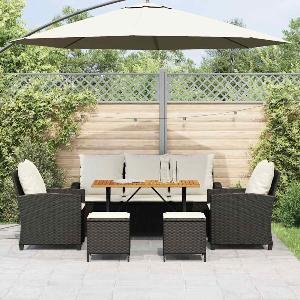 Outdoor-Sitzgruppe: Sofa, Sessel und Ottomane unter einem großen Sonnenschirm.