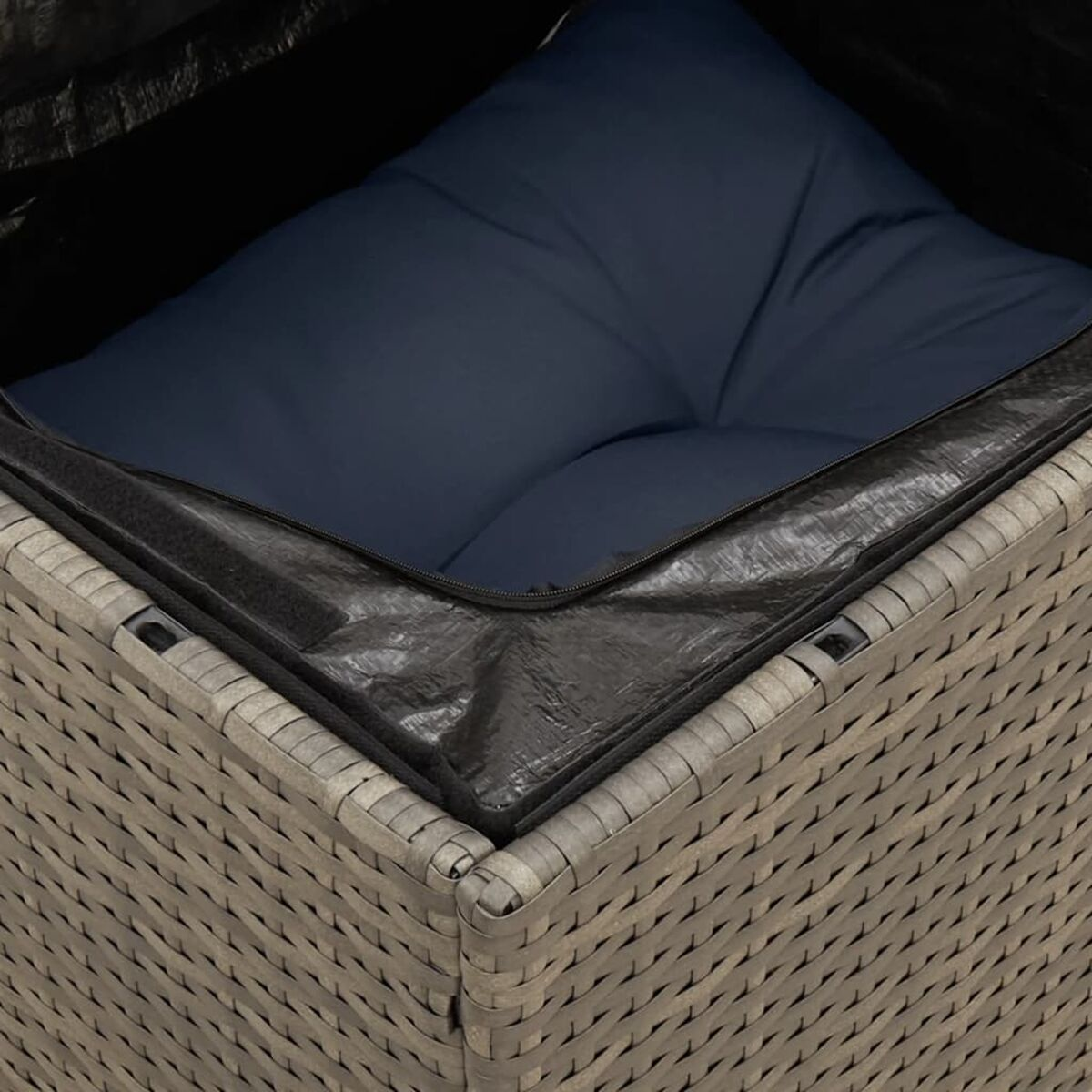 Primo piano di un cuscino blu scuro all'interno di un contenitore quadrato in vimini. Copertura nera.