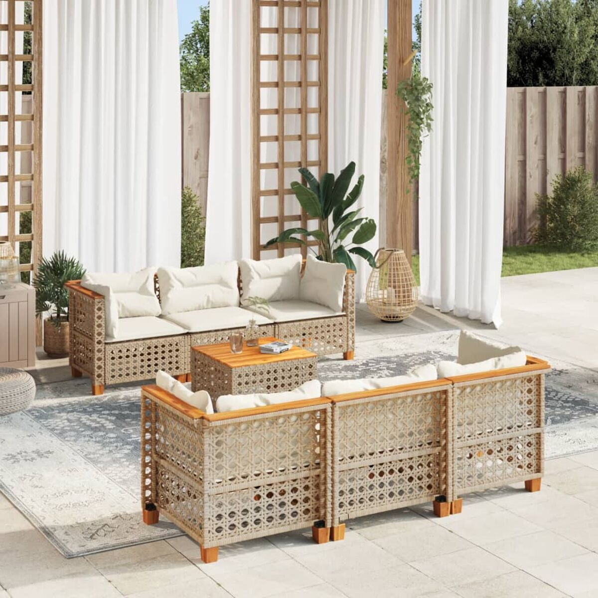 Un set da patio con un divano, due poltrone e un tavolo, su un patio con tende bianche.