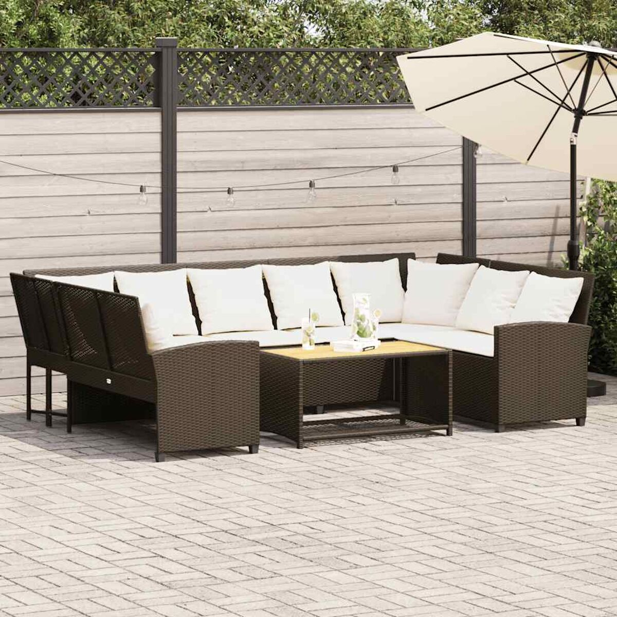 Conjunto de muebles de exterior con sofá grande, mesa de centro y cojines blancos.