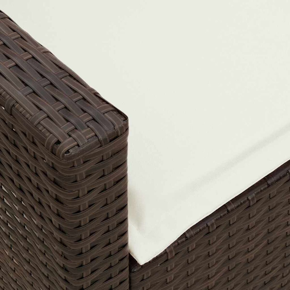 Primer plano de una esquina de muebles de patio de mimbre tejido marrón con cojín blanco.