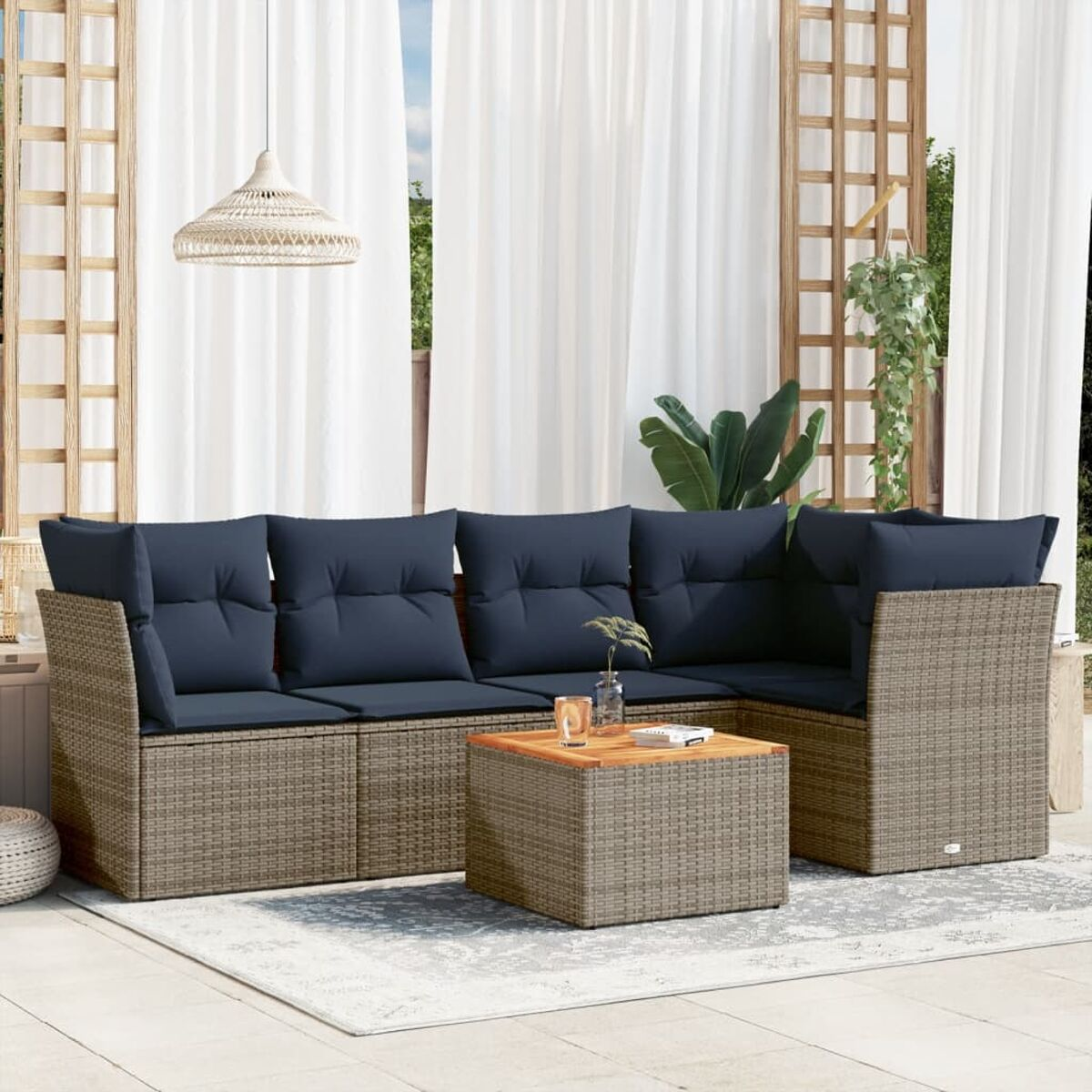 Set da patio esterno con divano, tavolino e divano angolare. Cuscini blu, vimini marrone chiaro.