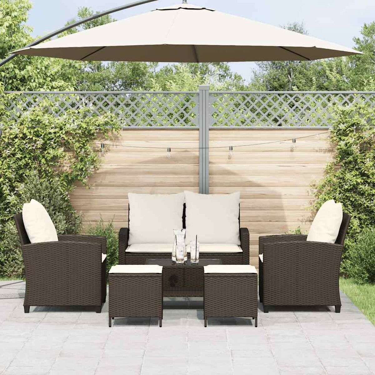 Set da patio esterno con posti a sedere, tavolo e ombrellone. Vimini marrone con cuscini color crema.