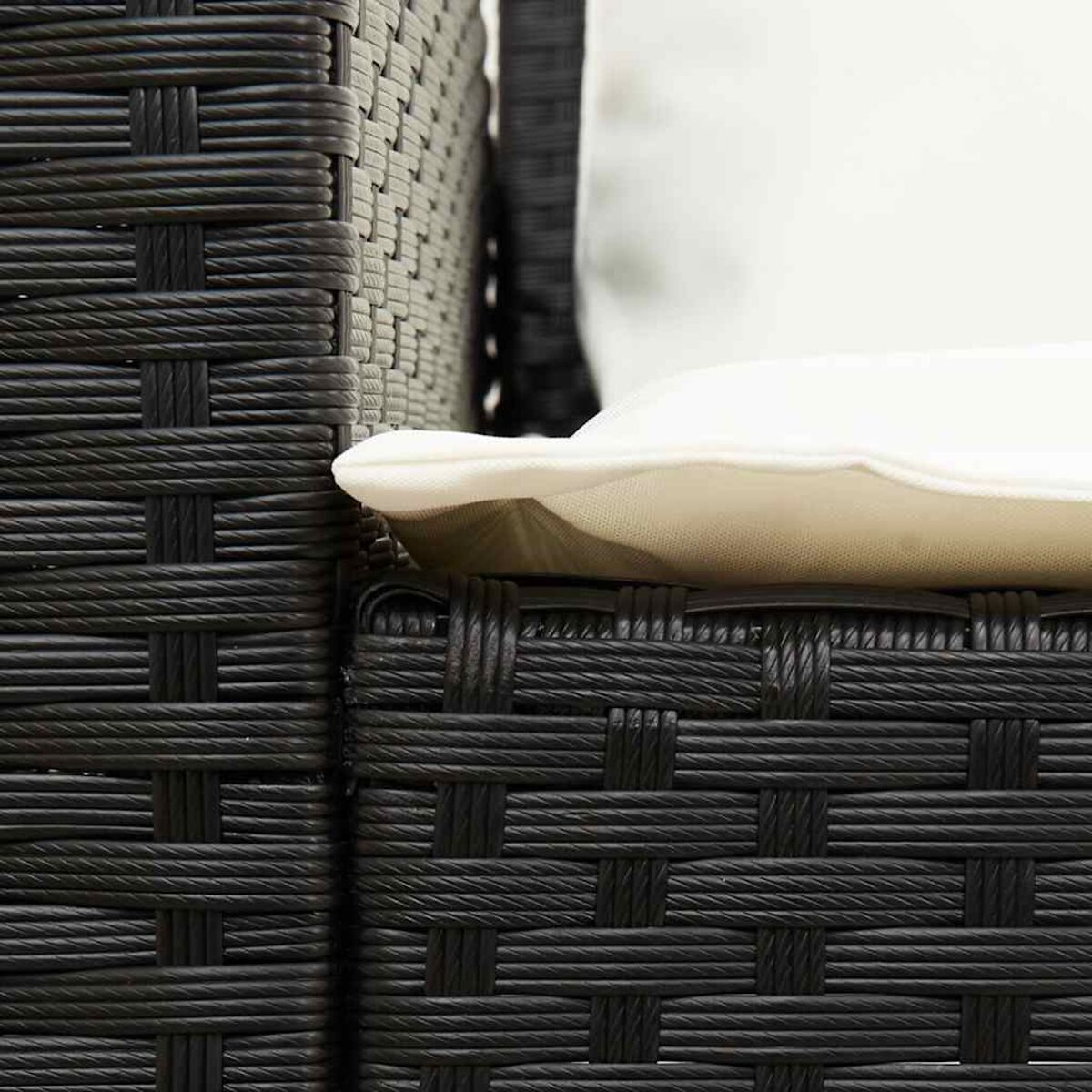 Primo piano di una sedia nera intrecciata e un cuscino bianco.