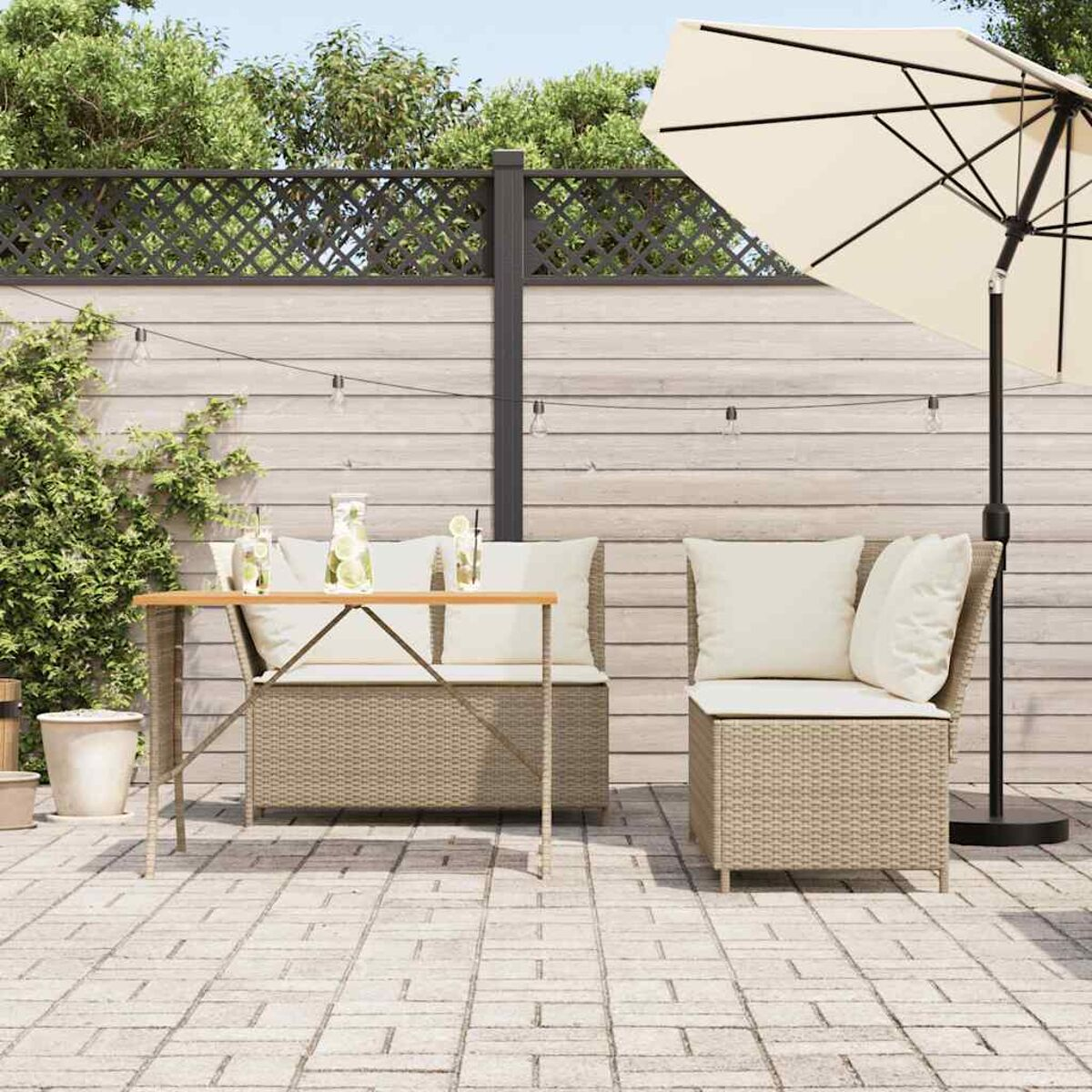 Gartenmöbel-Set aus Korbgeflecht mit Tisch, Sofa und Stuhl. Weiße Kissen, sonniger Tag.
