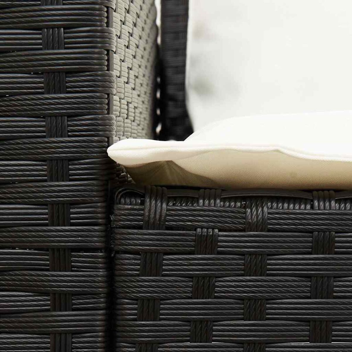 Primo piano di una sedia in vimini marrone scuro con un cuscino bianco.