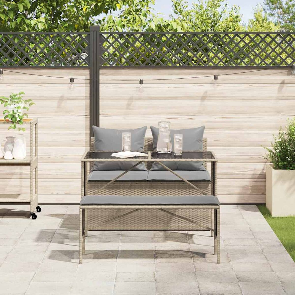 Gartensitzgruppe mit Tisch, Bank und zwei Gläsern.
