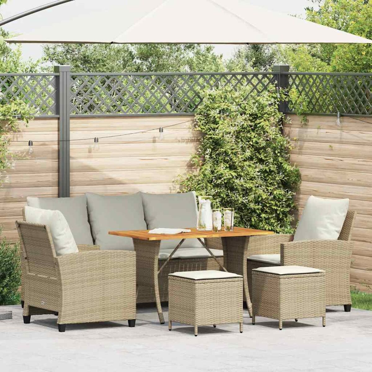 Set di mobili da esterno con tavolo, sedie e un grande ombrello. Colori beige e marrone.