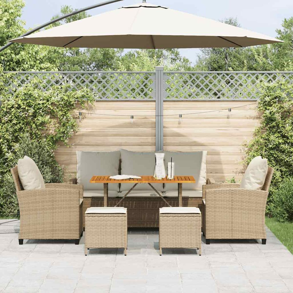 Set patio esterno con divano, poltrone e tavolo, con ombrellone sullo sfondo.