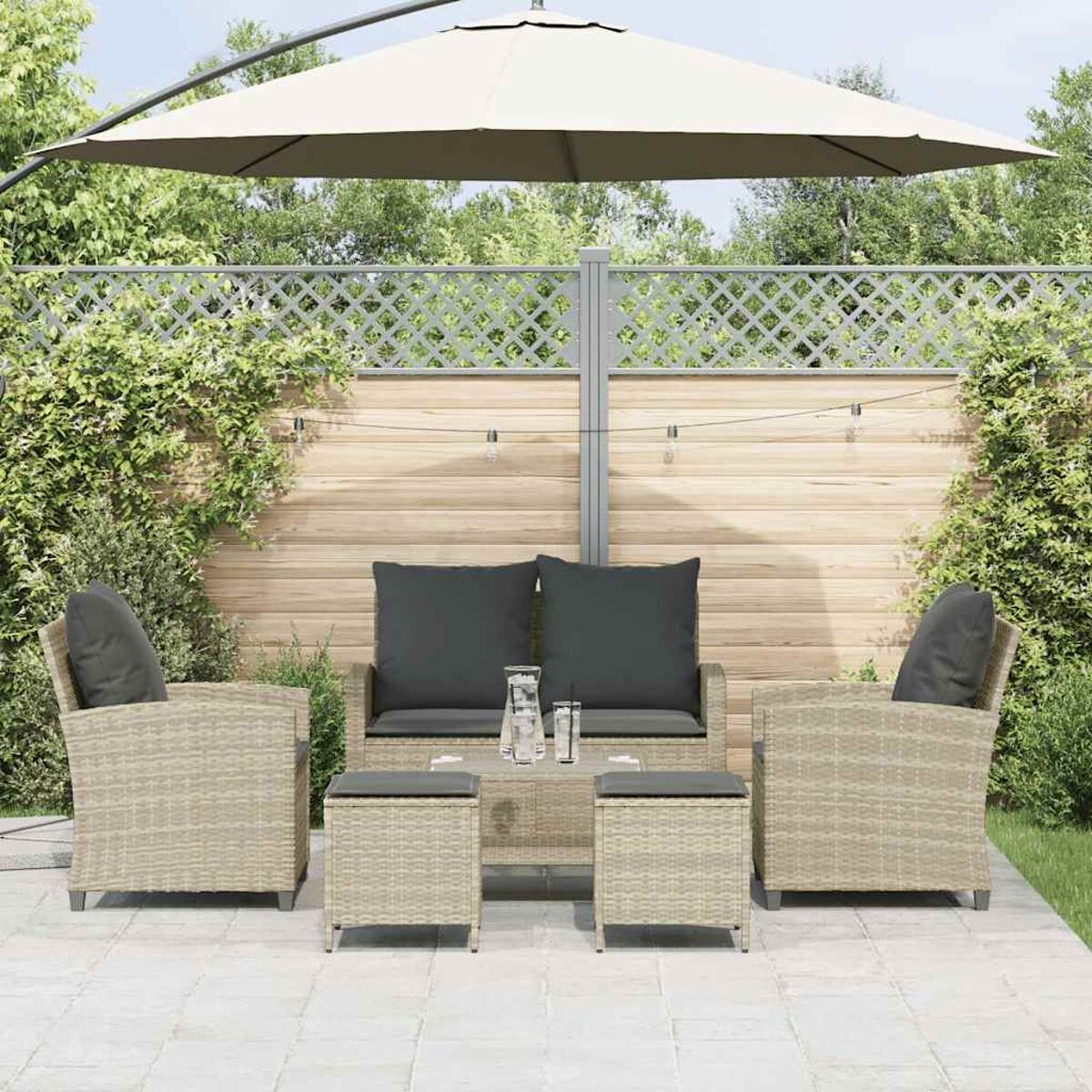Set patio con mobili in vimini beige, include divano, due sedie, due pouf e un ombrellone.