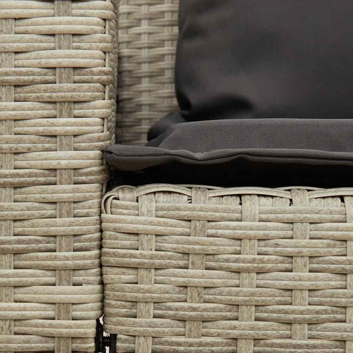 Nahaufnahme des Geflechts von Outdoor-Möbeln im Wicker-Stil und einem grauen Kissen.