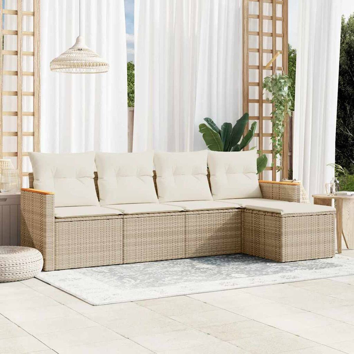 Un set da patio esterno con un divano beige chiaro intrecciato, cuscini e un tappeto, con luce decorativa.