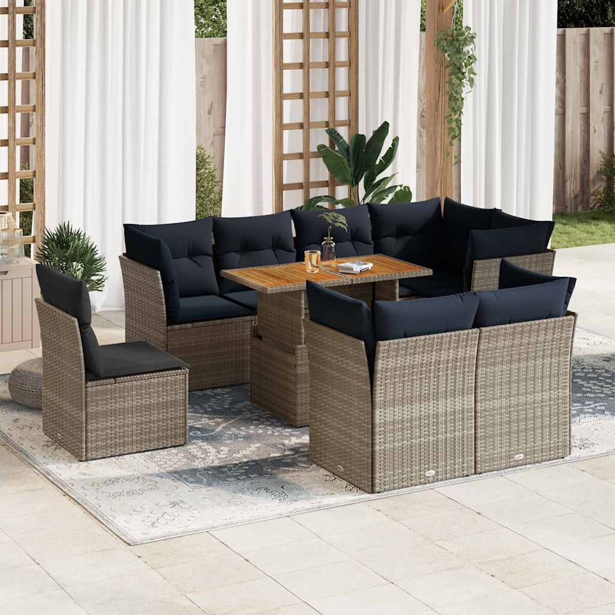 Set di mobili da esterno in rattan con tavolo e tappeto. Include sedie e divano.