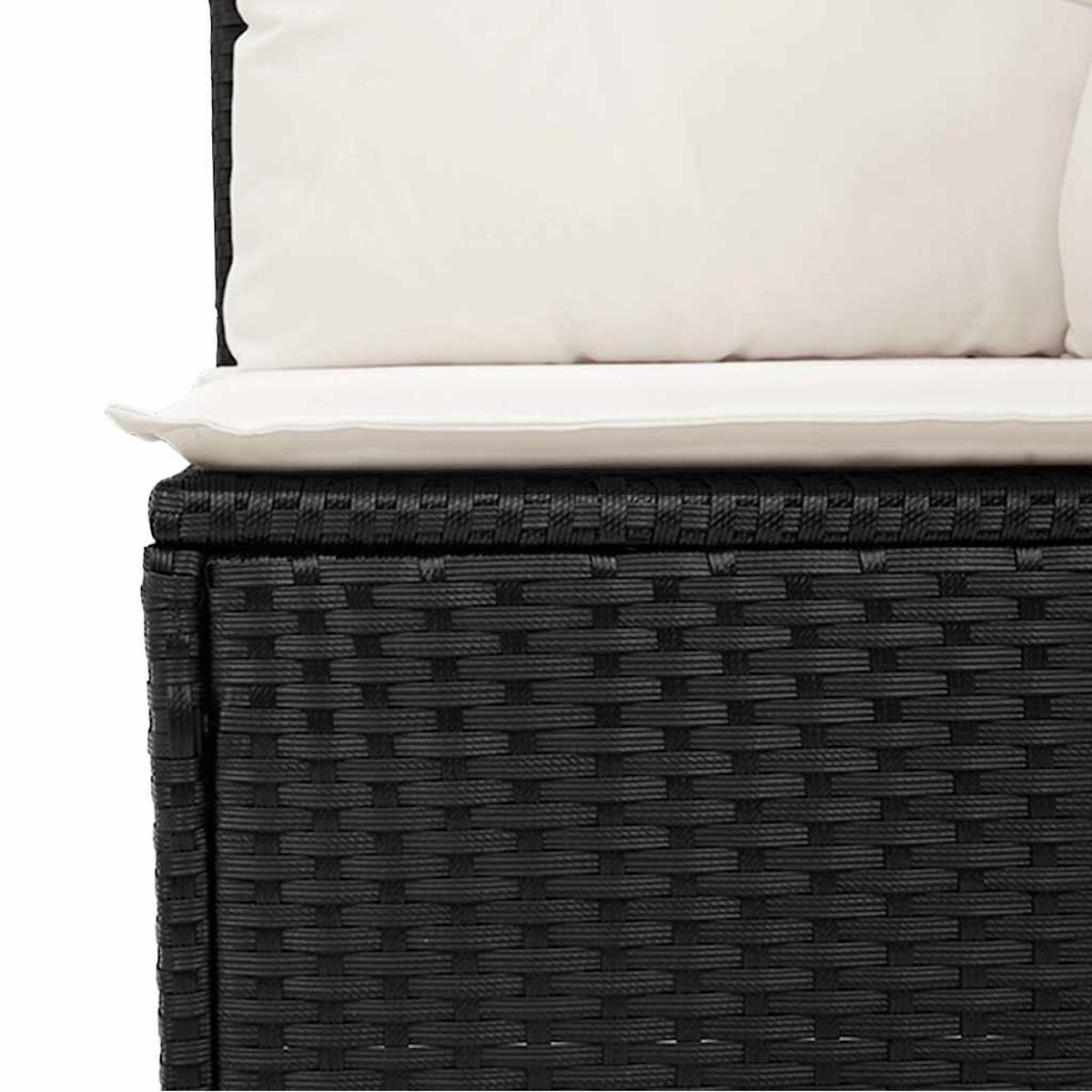 Primo piano di un divano in rattan nero intrecciato con cuscini bianchi.