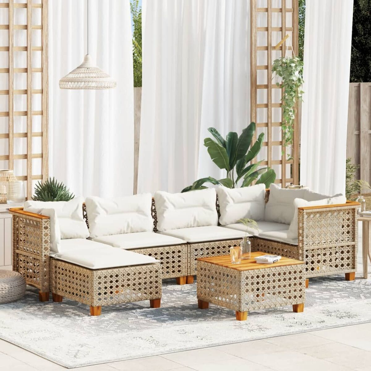 Rattan-Outdoormöbel-Set mit weißen Kissen und einem gemusterten Teppich.