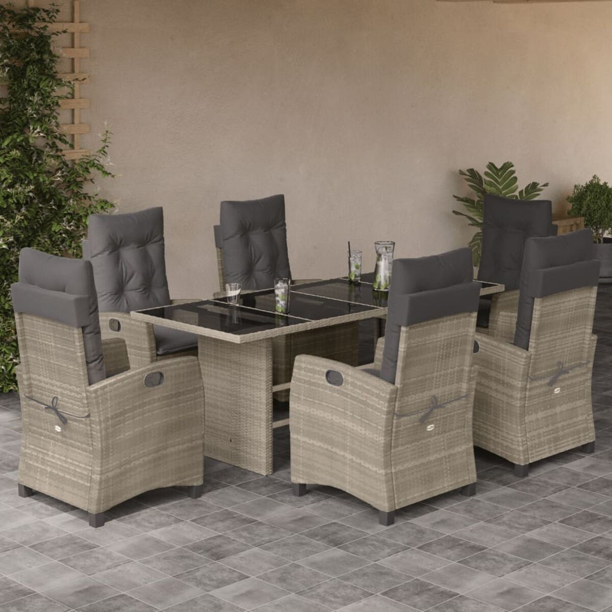 Set da pranzo da esterno in rattan con sei sedie e un tavolo con piano in vetro.