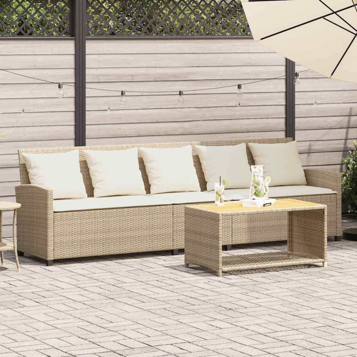 Set patio esterno con divano, tavolino e elementi decorativi.