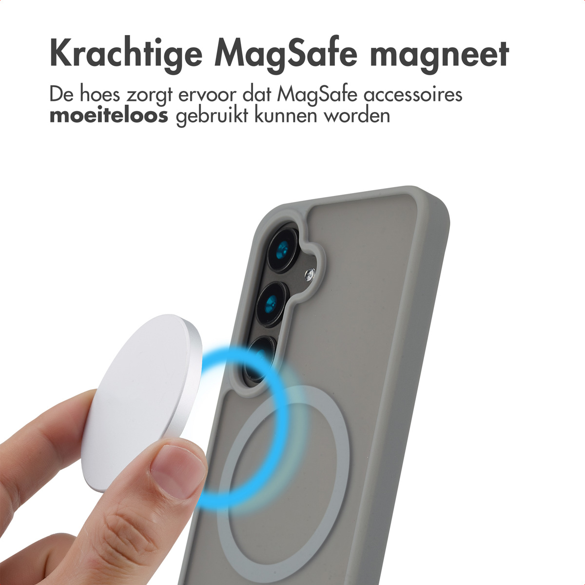 Een hand die een wit MagSafe-accessoire vasthoudt in de buurt van een grijze telefoonhoes op een witte achtergrond.