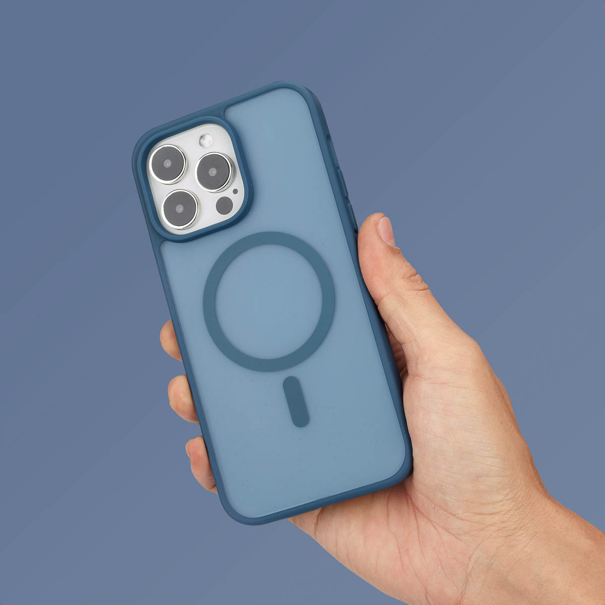 Main tenant un téléphone bleu avec un étui, montrant l'arrière avec un anneau MagSafe, fond bleu.