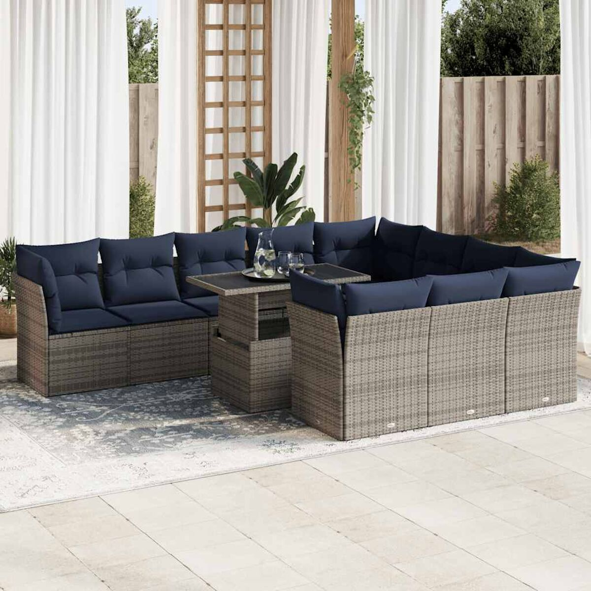 Set di mobili da esterno, divano in rattan grigio, tavolo e sedie. Cuscini blu scuro.