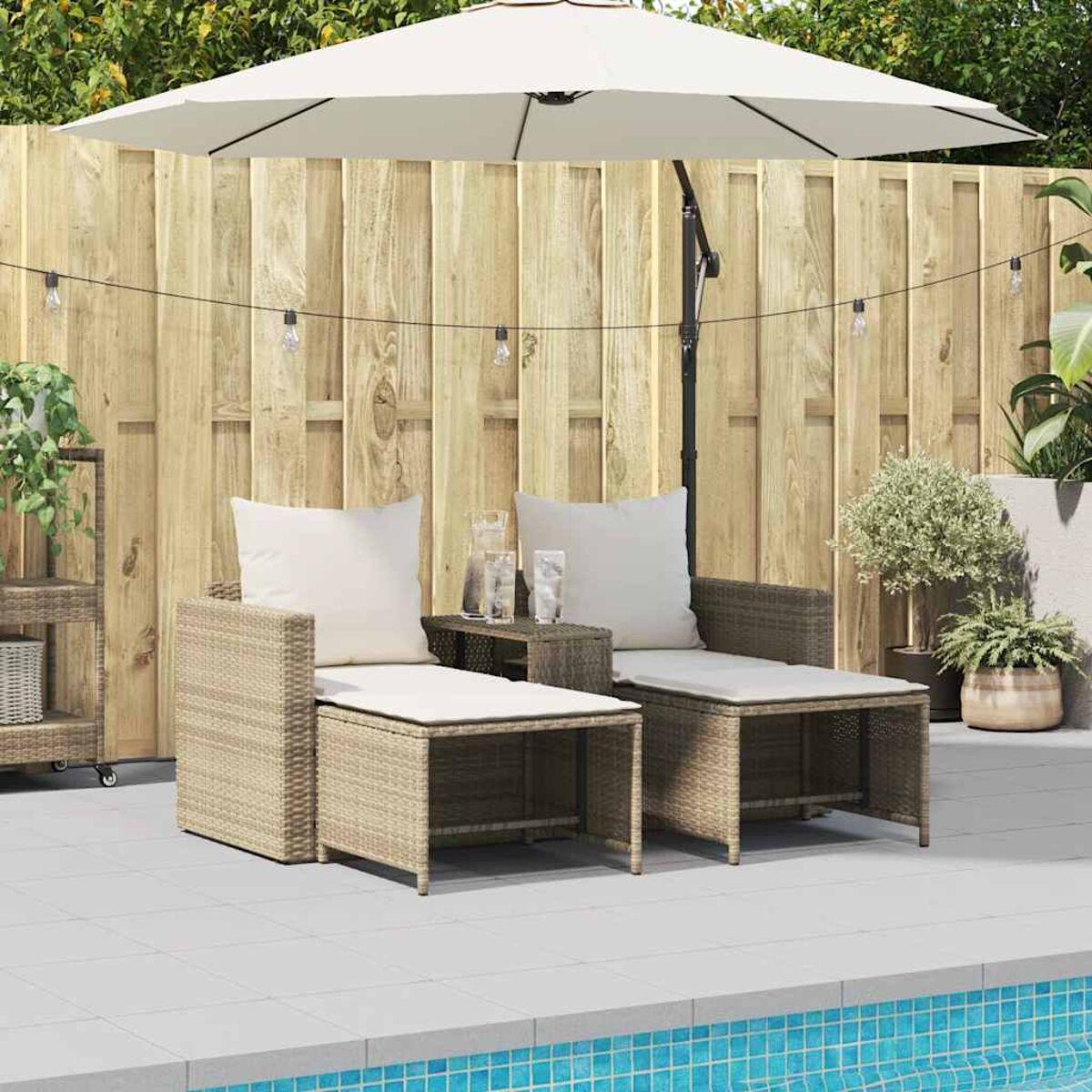 Gartenset mit zwei Stühlen, einem Tisch, einem Sonnenschirm und einem Holzzaun im Hintergrund.