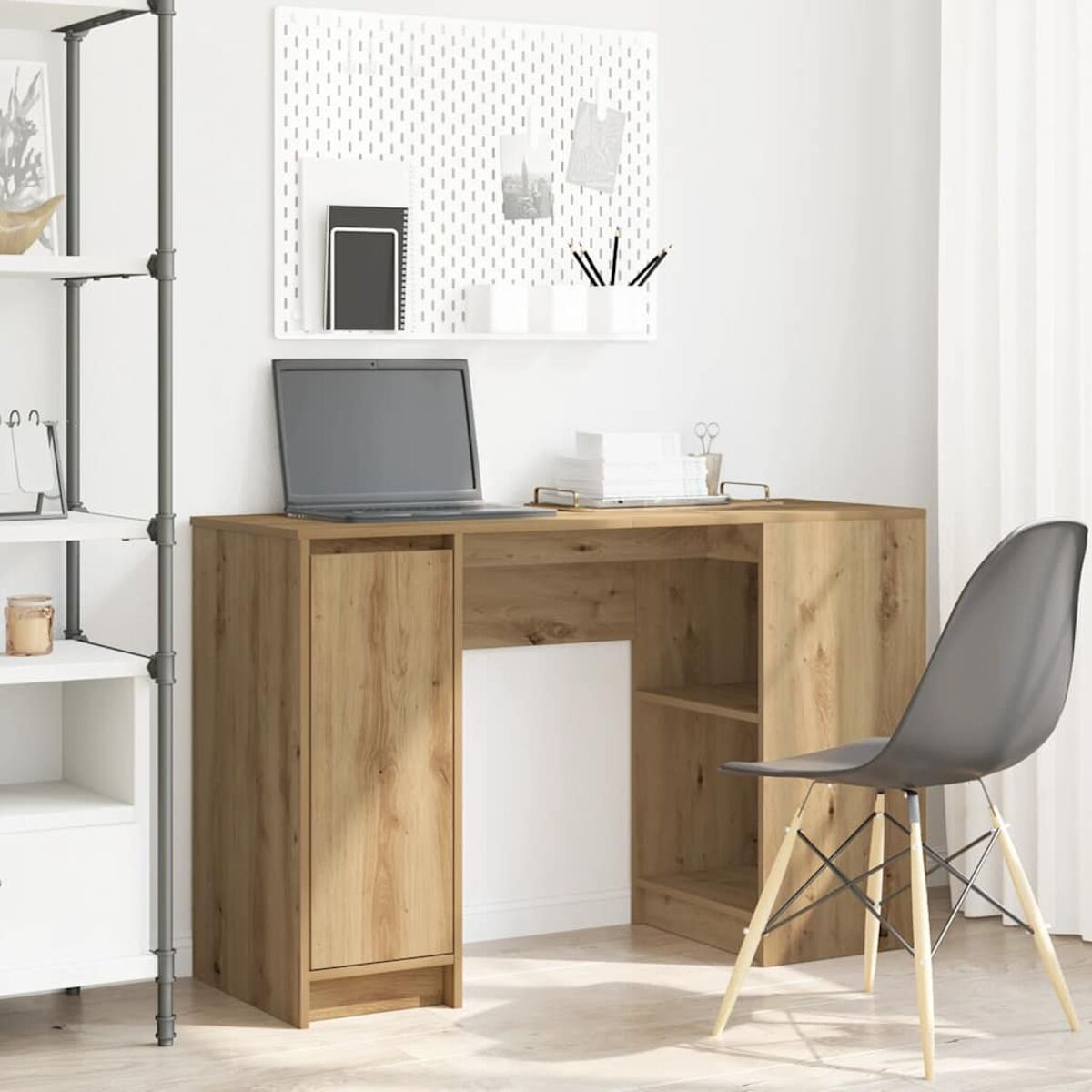 Holzschreibtisch mit Laptop, Schrank und Stuhl. Eine Lochwand mit Büroartikeln hinten.