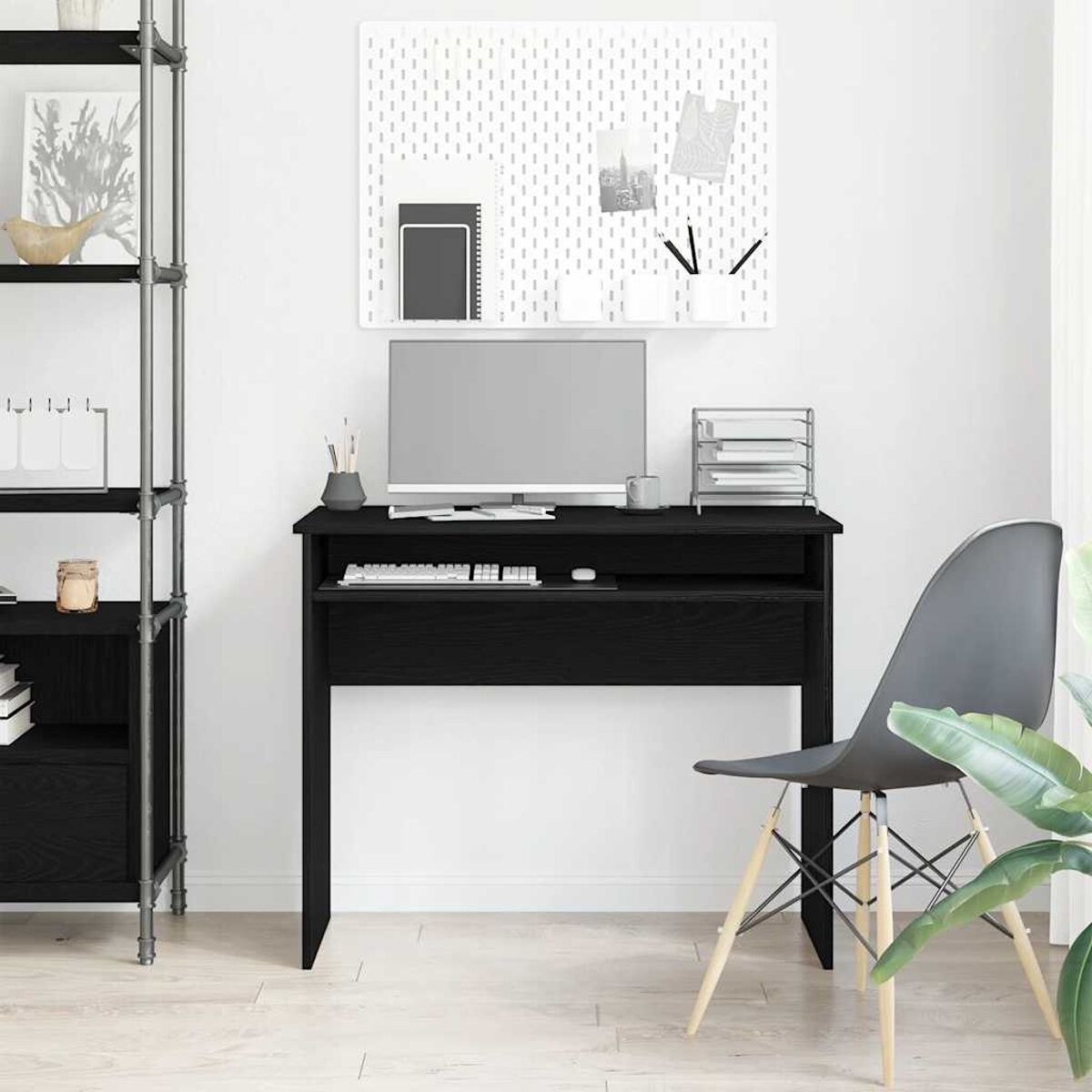 Schwarzer Schreibtisch mit Computer und Zubehör. Stuhl und Regal im Hintergrund.