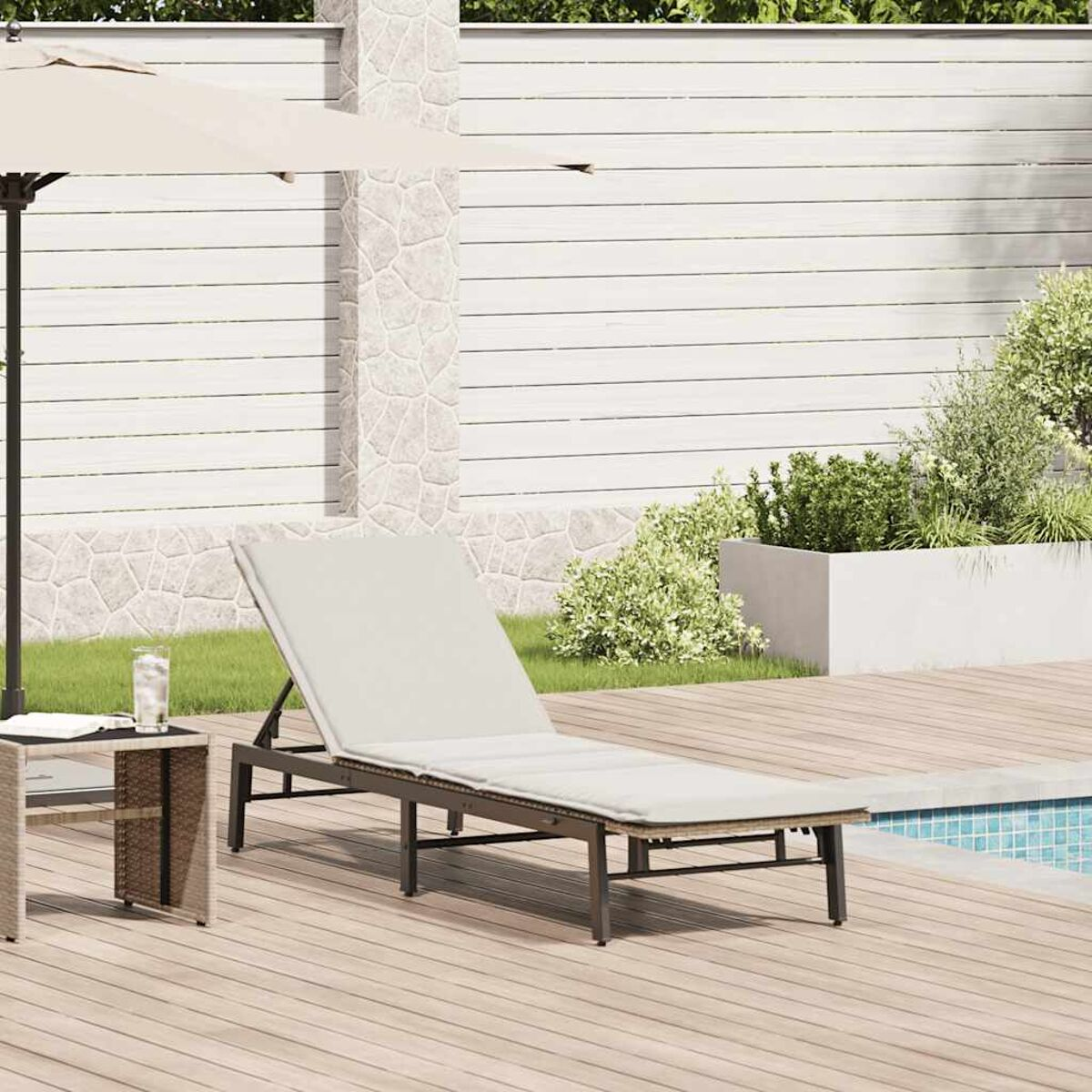 Lettino beige con cuscino bianco, accanto a un tavolino e una piscina.