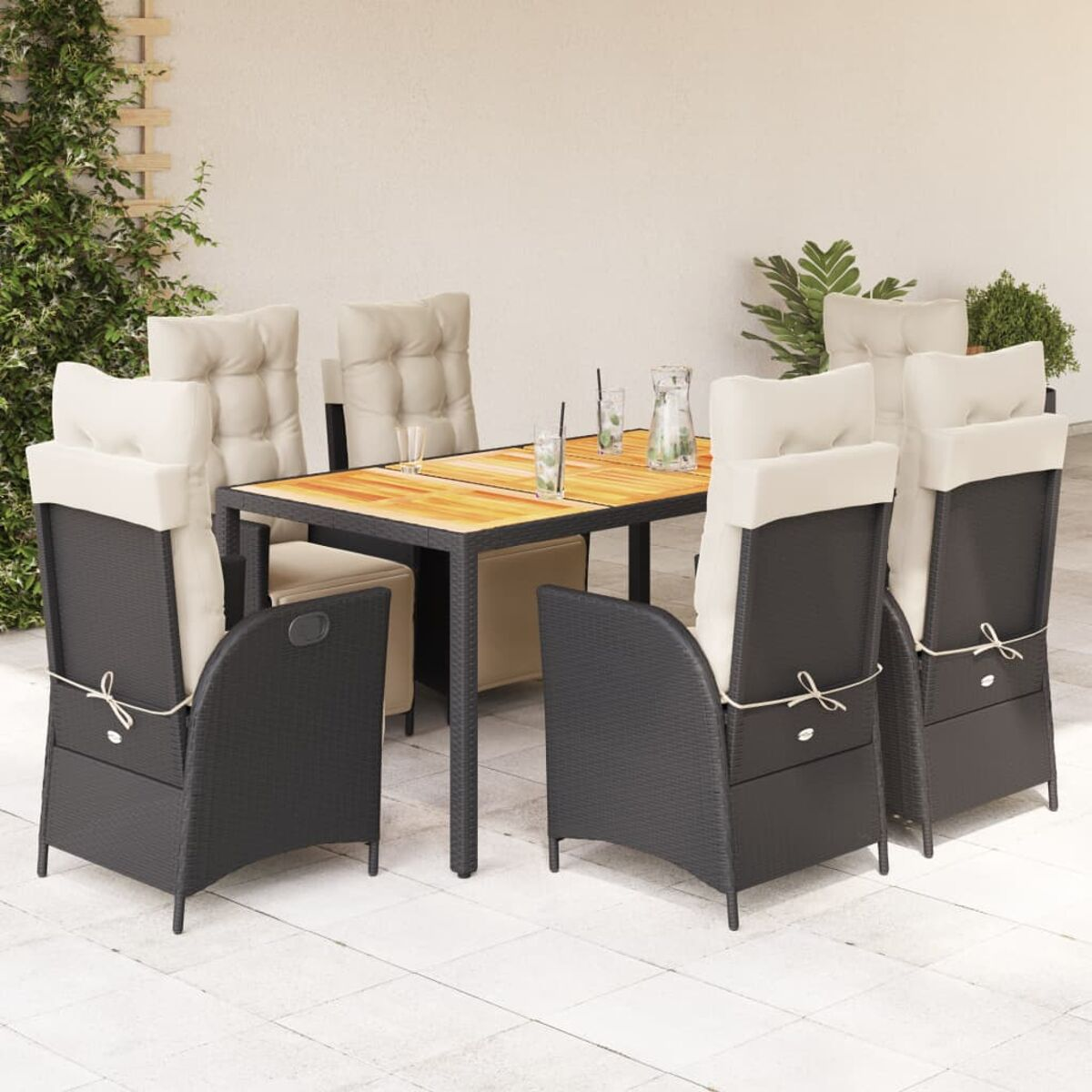 Set da pranzo all'aperto con tavolo in legno e sedie in vimini nere. Cuscini beige.