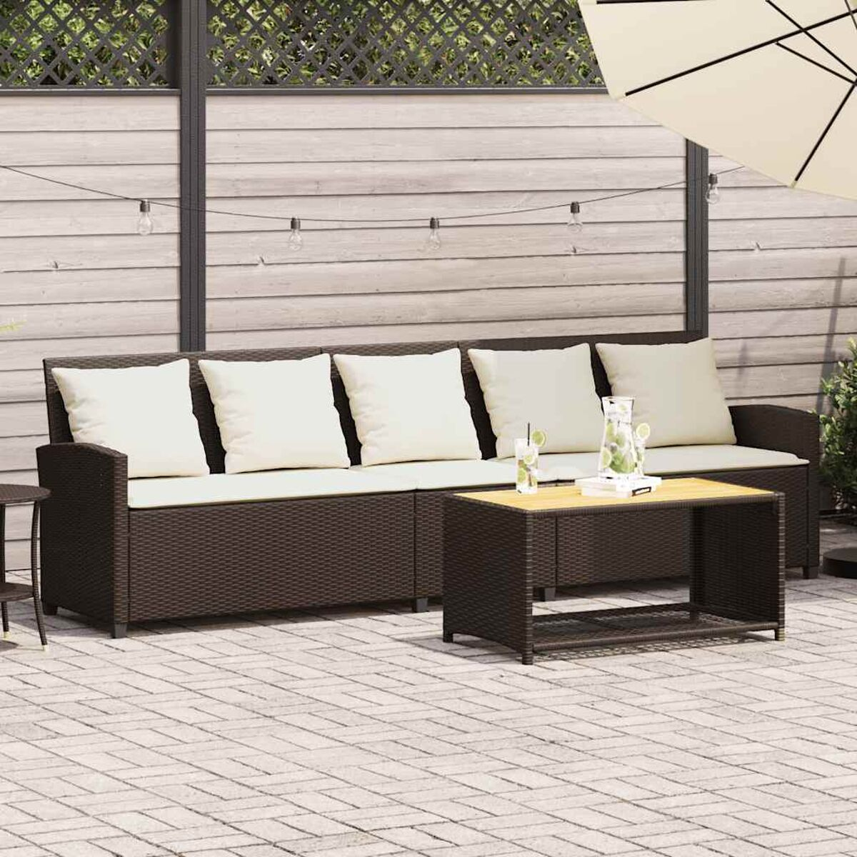 Set di mobili da patio con divano, tavolo e cuscini.