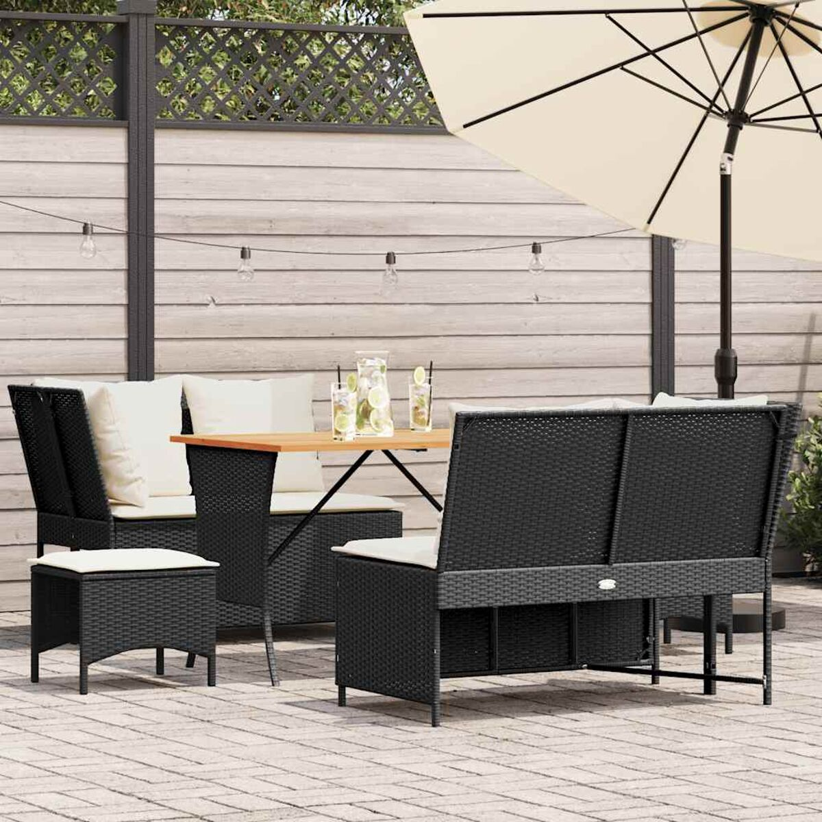 Outdoor-Rattan-Möbelset mit Tisch, Sonnenschirm und Lichtern.