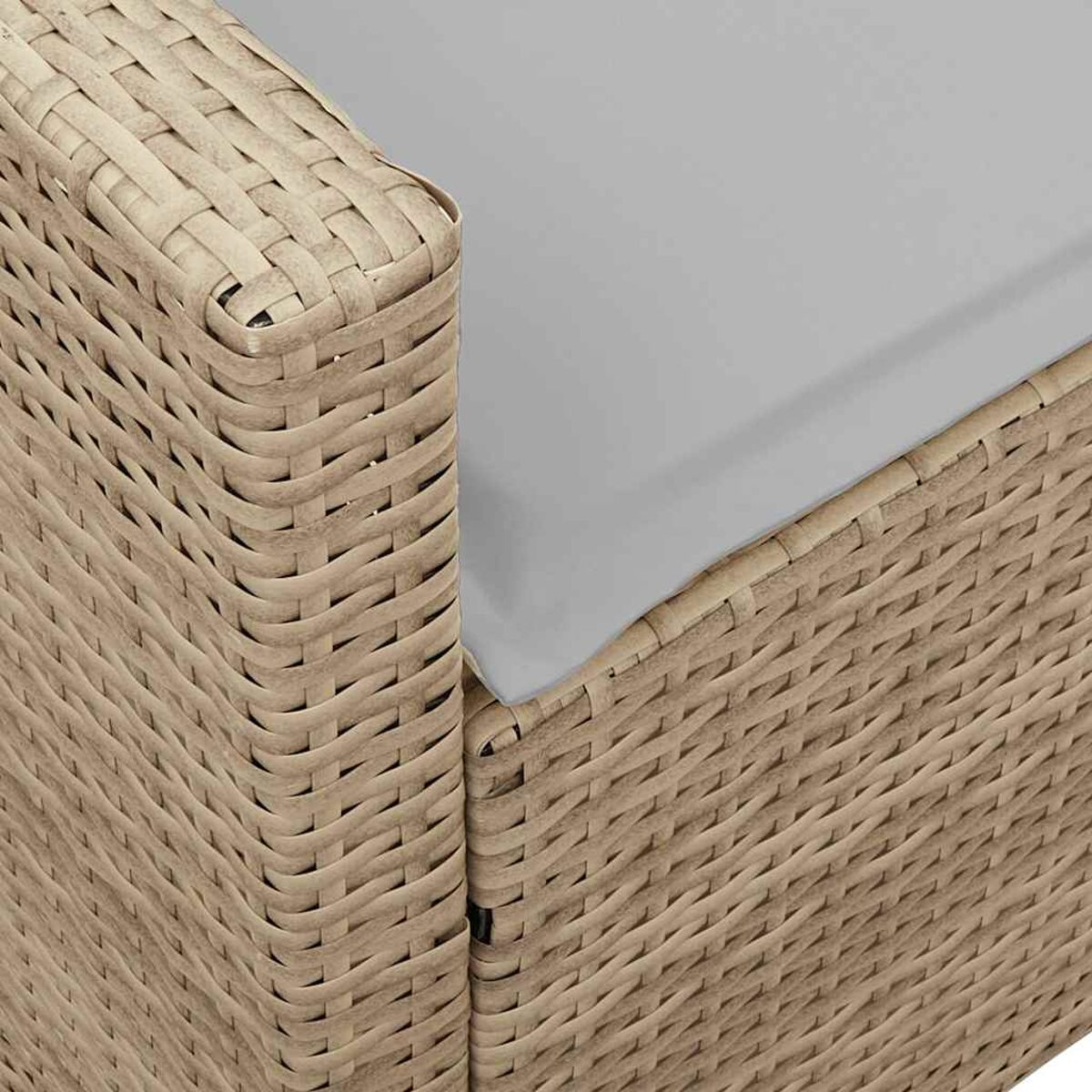 Primo piano di un angolo di mobile beige intrecciato con un cuscino grigio.