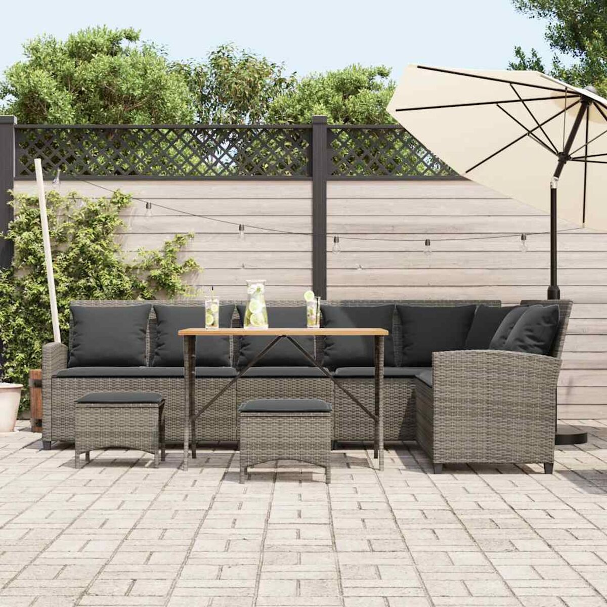Set da patio esterno con tavolo, sedie e ombrellone.