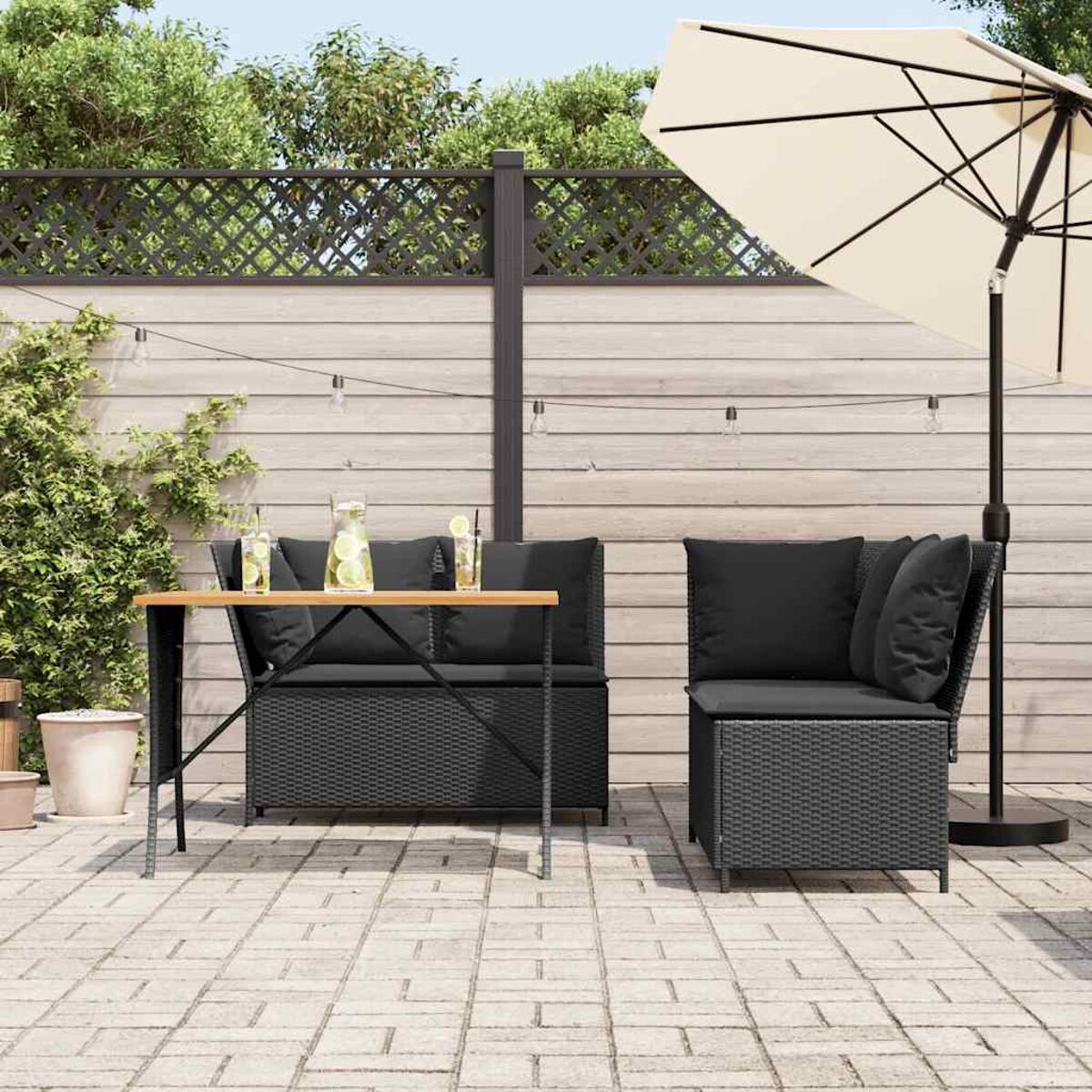 Set da patio esterno con tavolo, divano e sedia sotto un ombrellone.
