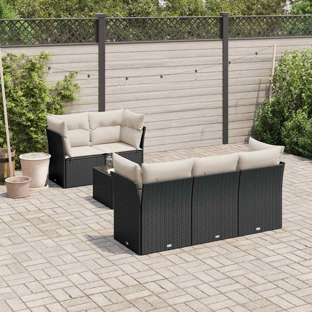 Set divani in rattan nero da esterno su patio in mattoni.