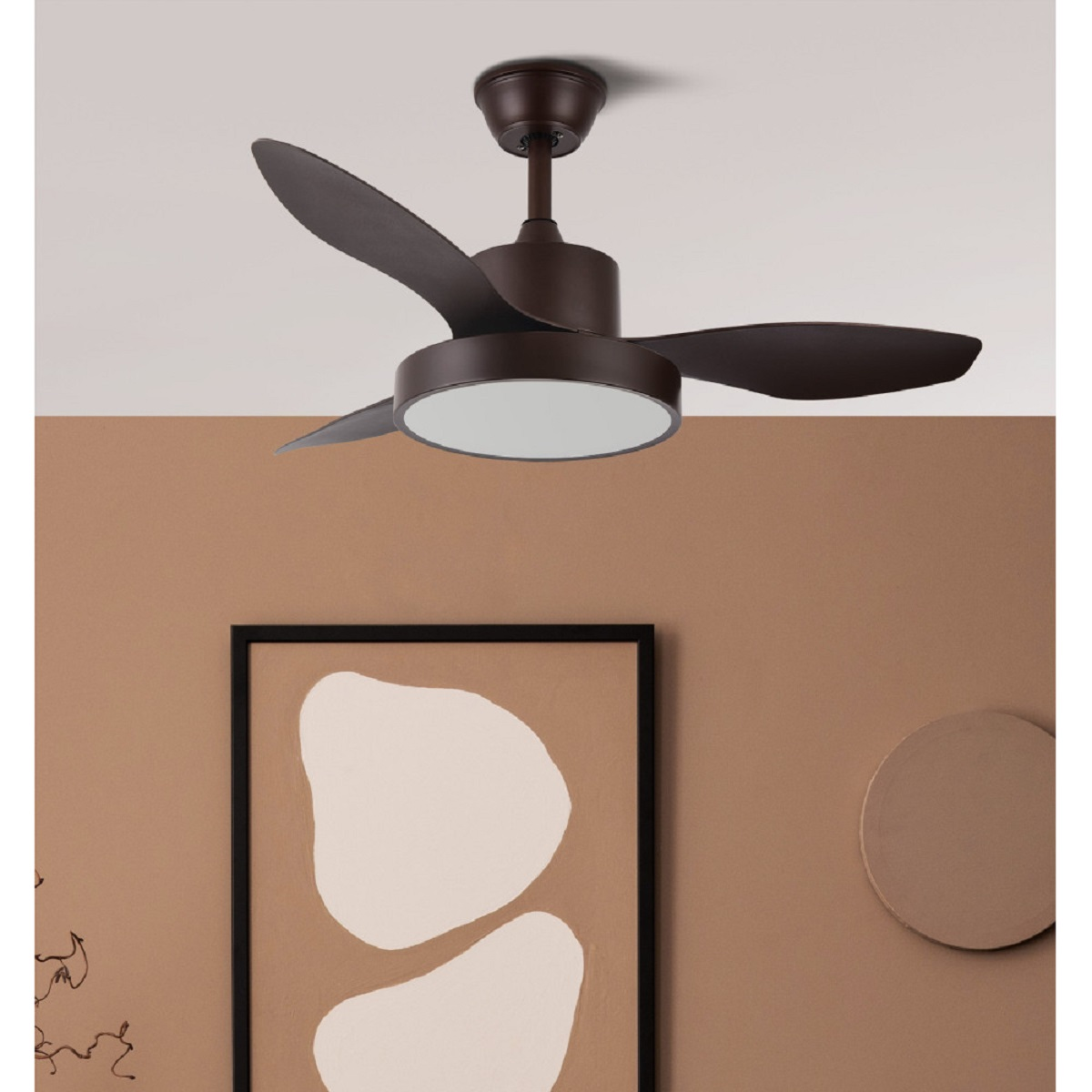 Un ventilador de techo marrón con tres aspas y una luz blanca. Cuelga de una pared marrón.