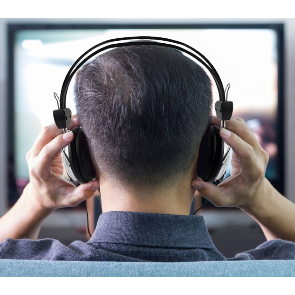 Persona con cuffie, guarda lo schermo della TV.