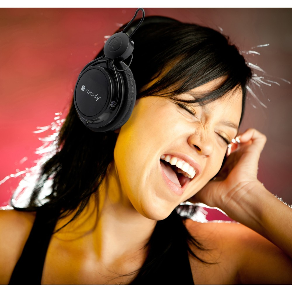 Donna con cuffie, sorridente e che canta. Sfondo rosso e arancione con logo TECHly sulle cuffie.
