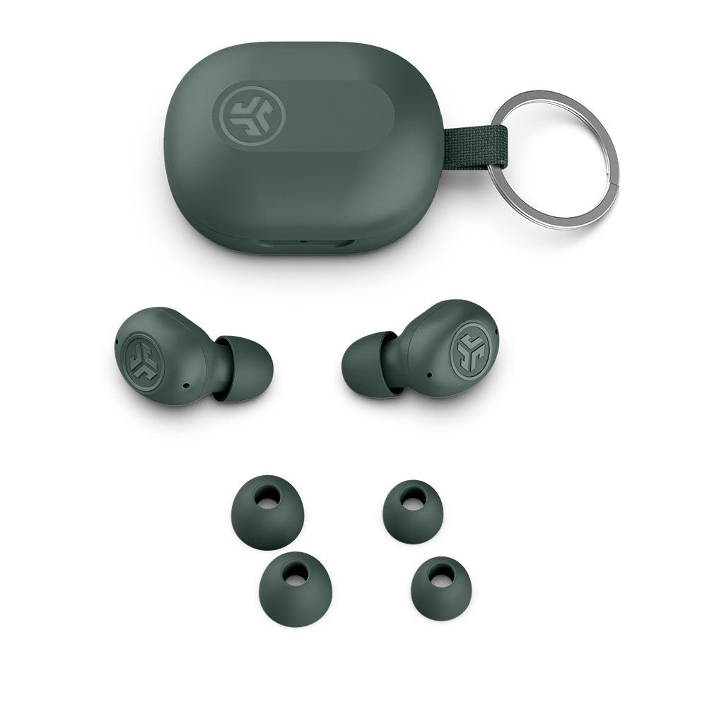 Auricolari verdi, custodia di ricarica e gommini. La custodia ha un anello metallico.