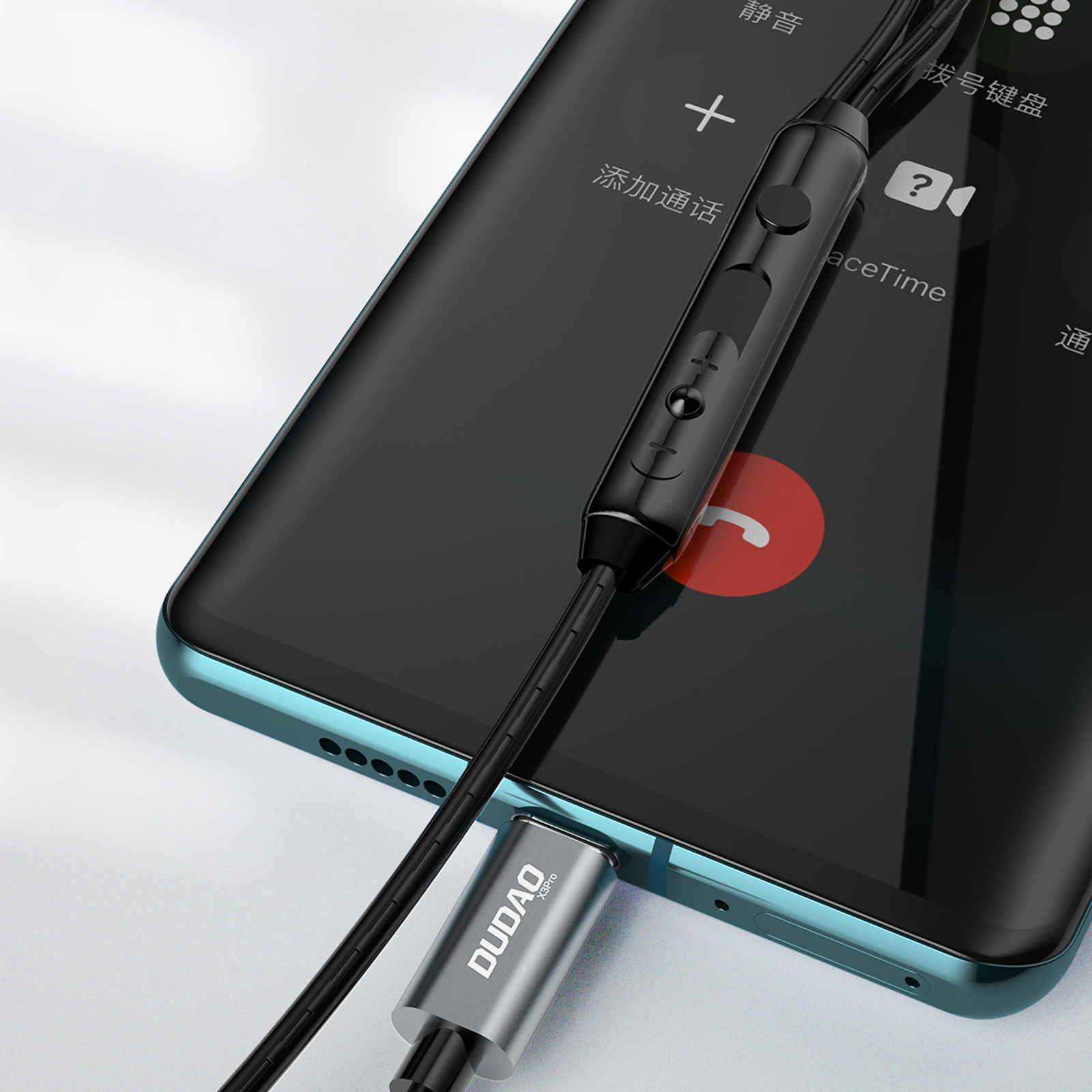 Auricolari collegati a un telefono, con un pannello di controllo nero. Il telefono è su una superficie blu.