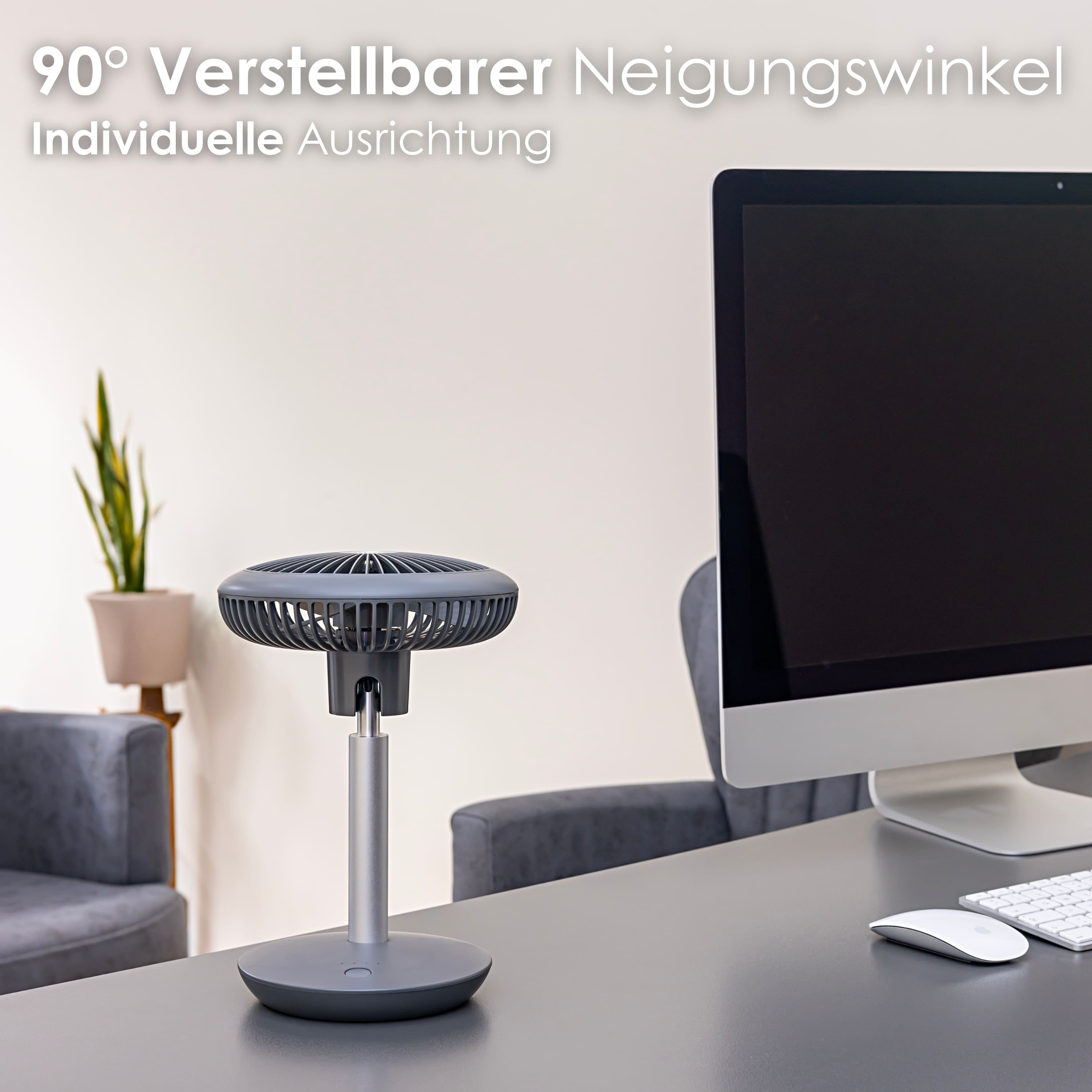 Schreibtisch mit kleinem Ventilator auf Ständer, Computermonitor und Tastatur.