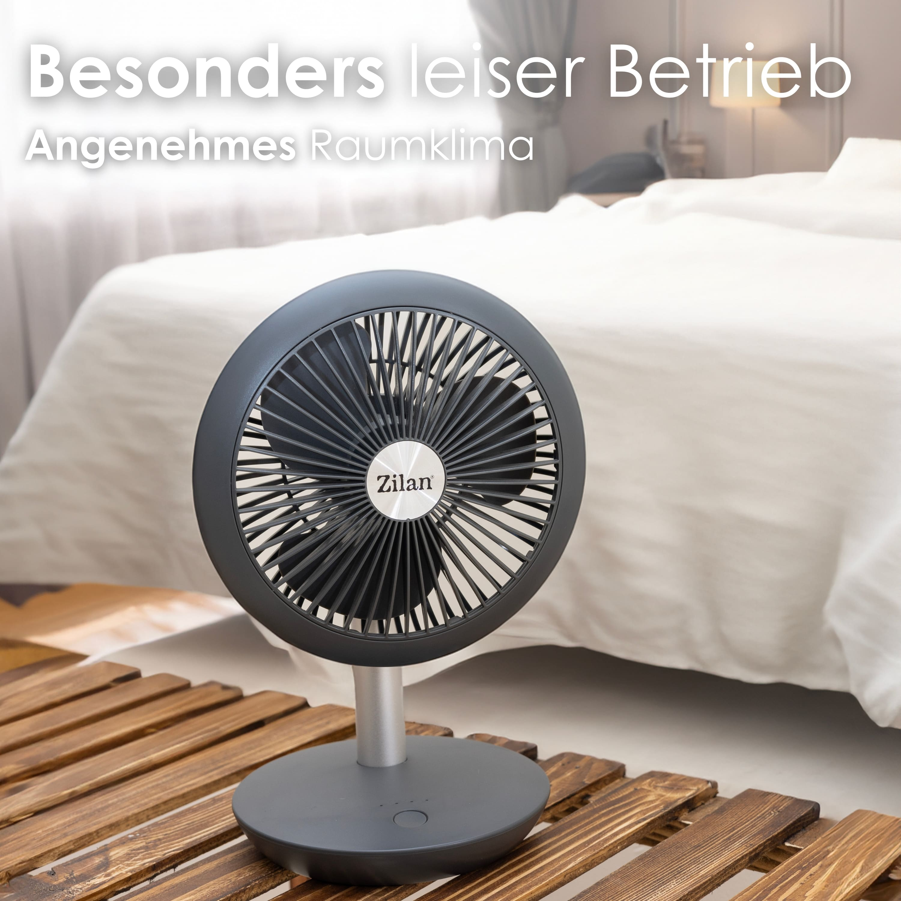 Ein schwarzer Ventilator auf einem Ständer, mit deutschem Text und Bett.