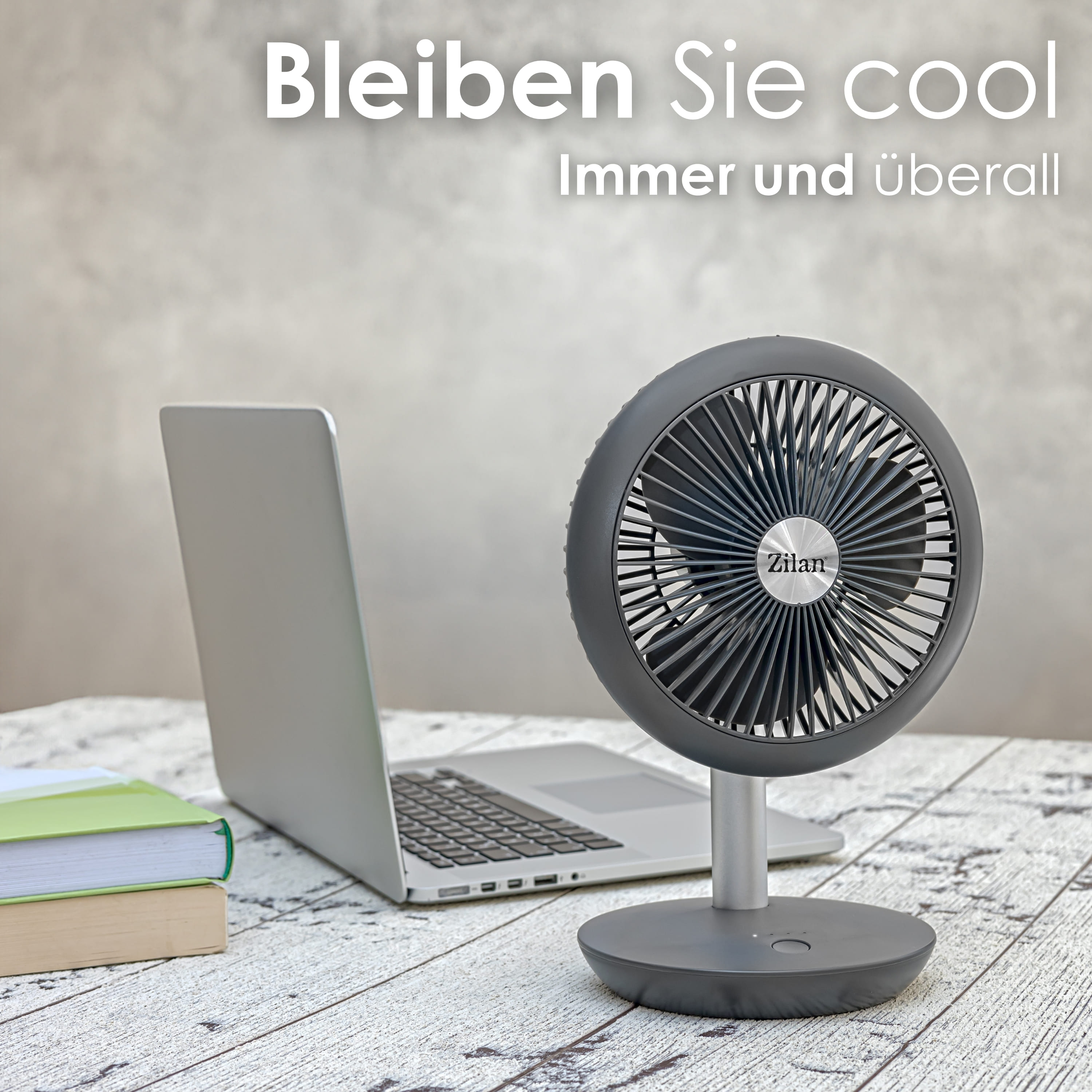 Ein grauer Ventilator auf einem Tisch mit Laptop und Büchern. Text: Bleiben Sie cool, immer und überall.