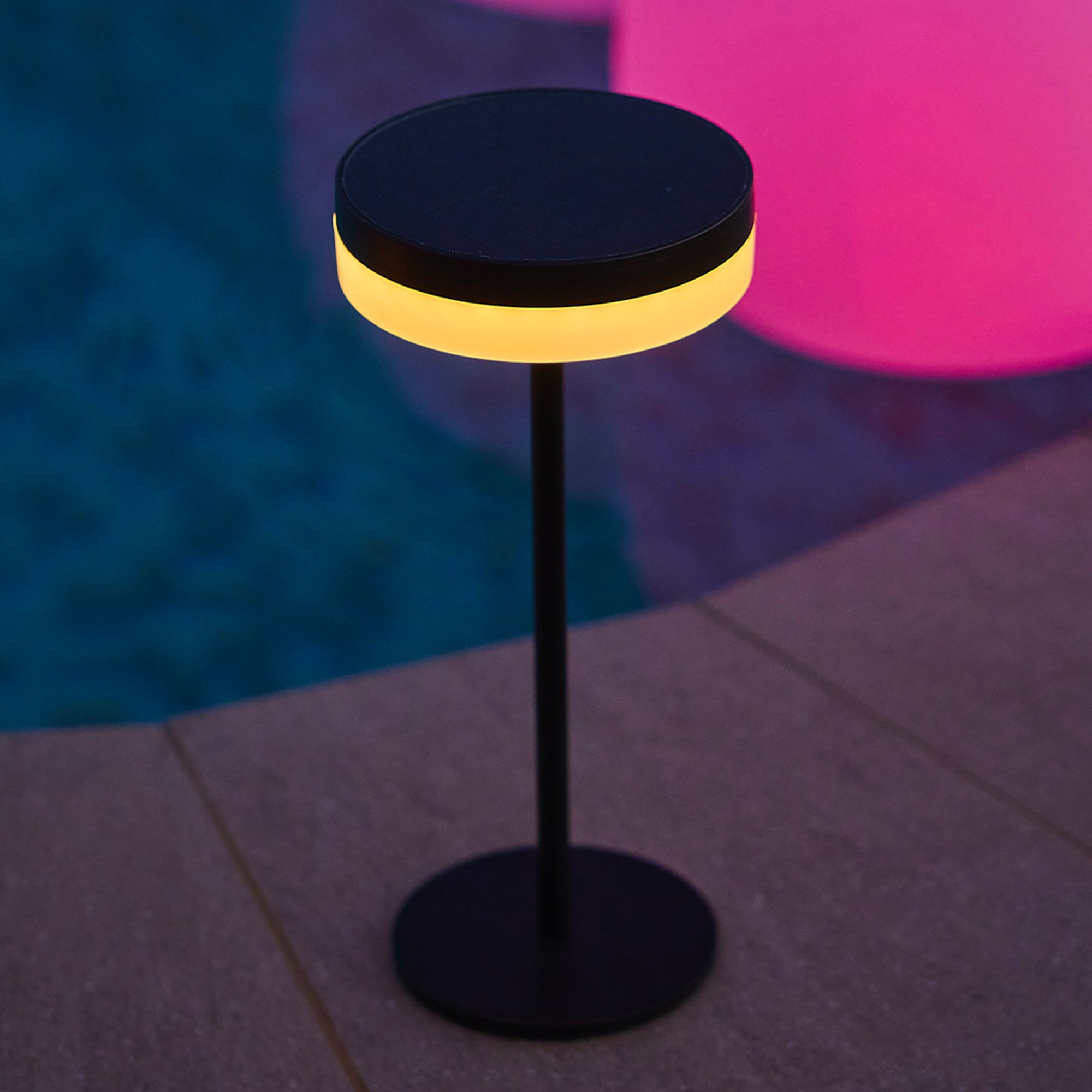Moderne schwarze Outdoor-Tischlampe mit Lichtring und dunklem Sockel.