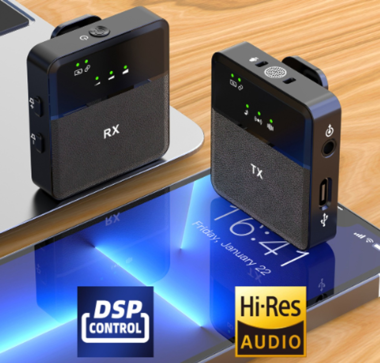 Zwei kleine, schwarze, drahtlose Mikrofone mit USB-Anschlüssen, beschriftet RX und TX, auf einem Laptop und Telefon.