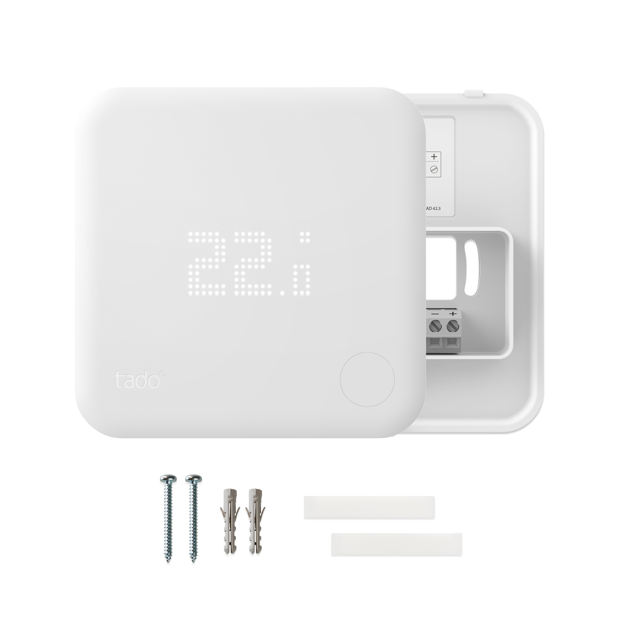 White Tado smart thermostat with display showing 22. Accessories include screws and mounting strips.