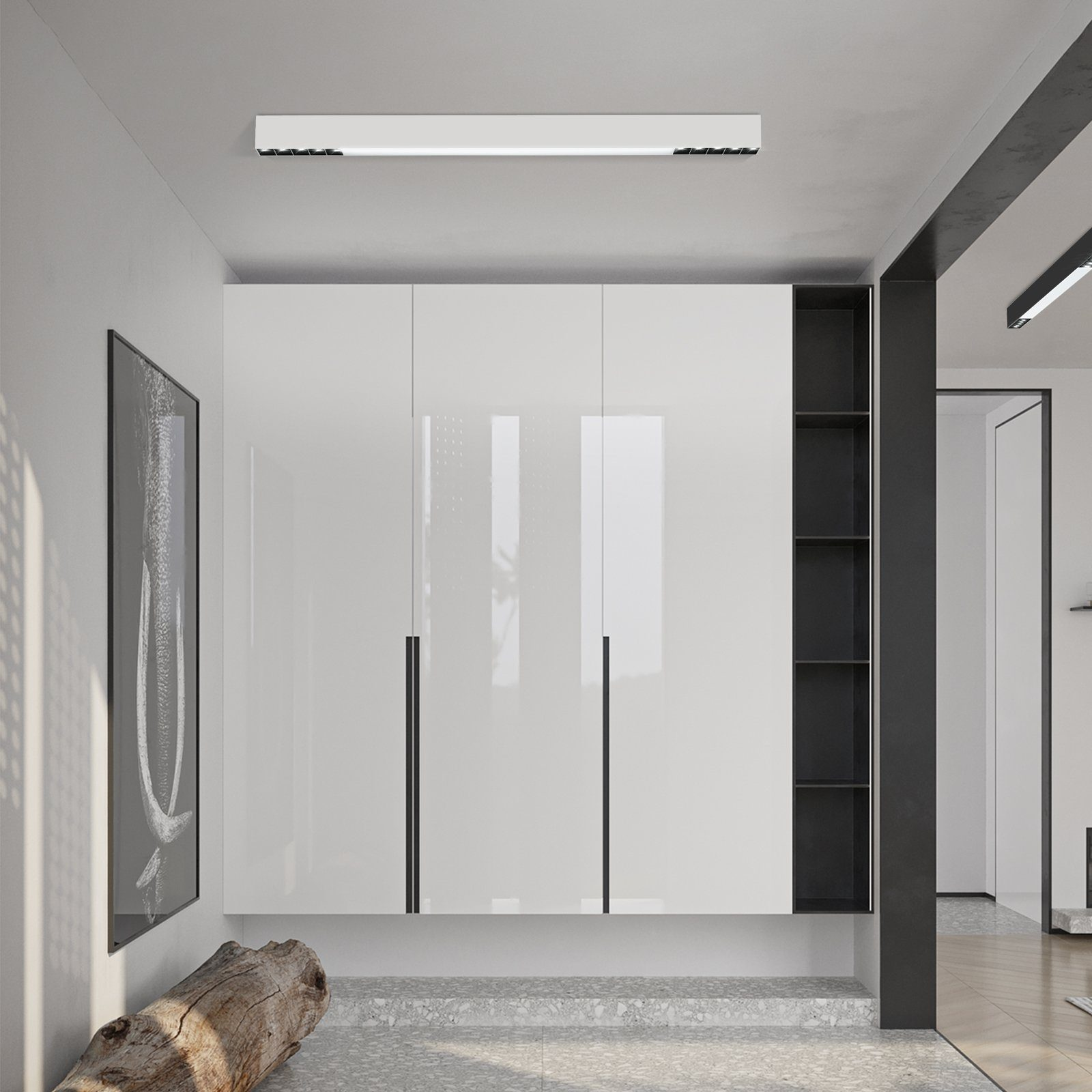 Un armario blanco moderno con tiradores negros y estantes abiertos, junto a una obra de arte enmarcada en negro.