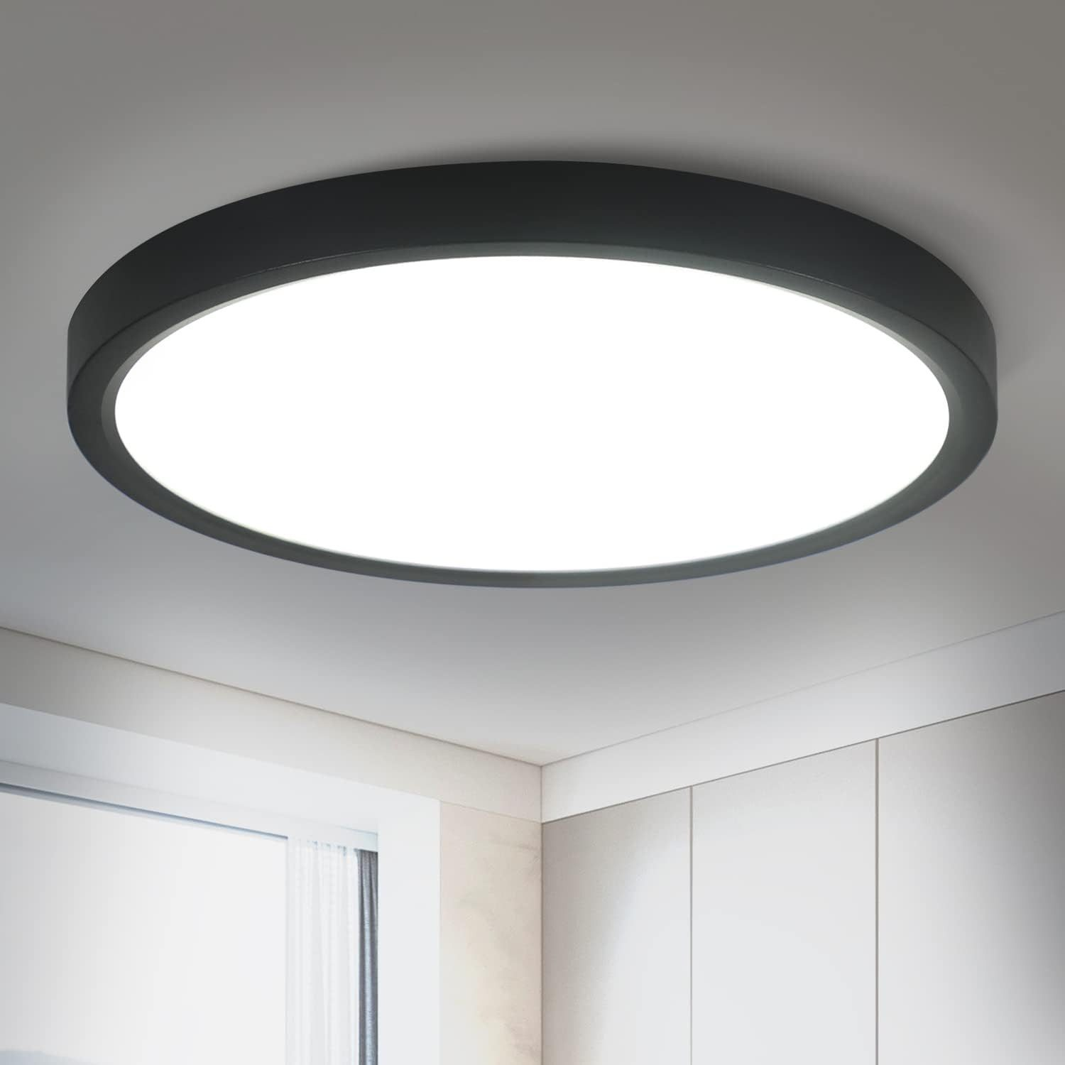 Una luce da soffitto rotonda, nera e a filo. Emette una luce bianca brillante.