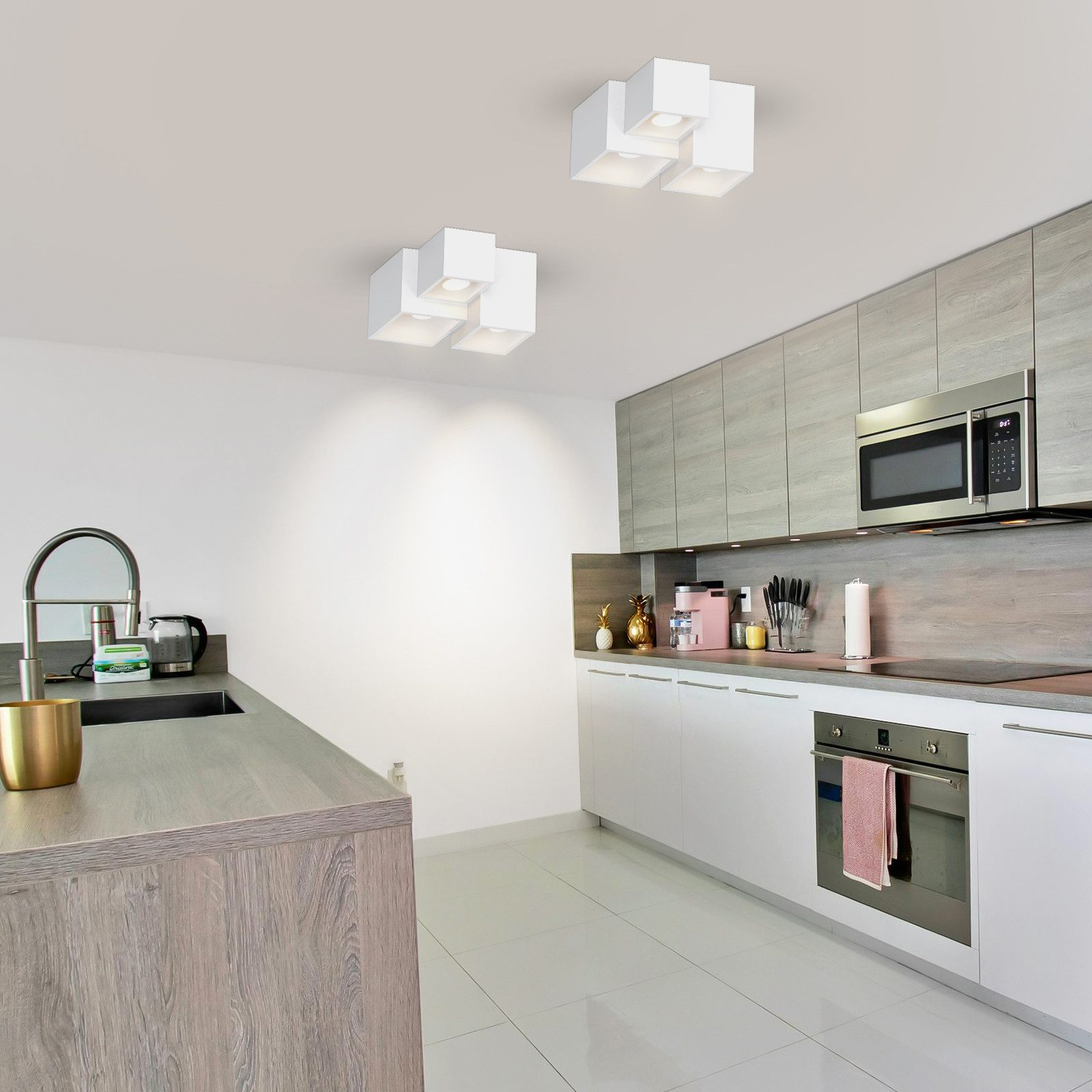 Escena de cocina moderna con gabinetes blancos e iluminación superior.